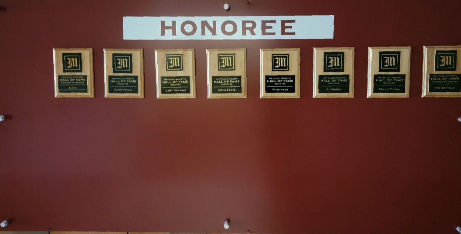 A wall with plaques on it that says honoree