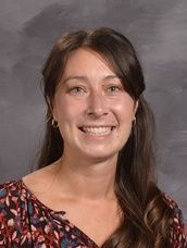 A woman wearing a printed shirt smiles for the camera