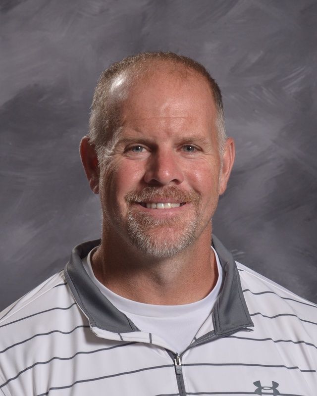 A man with a beard is smiling for the camera