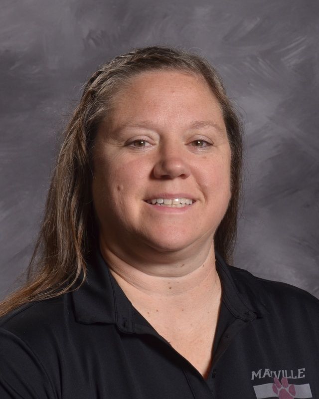 A woman with long hair and wearing a black shirt is smiling for the camera.
