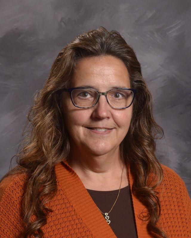 A woman with long hair smiling for the camera