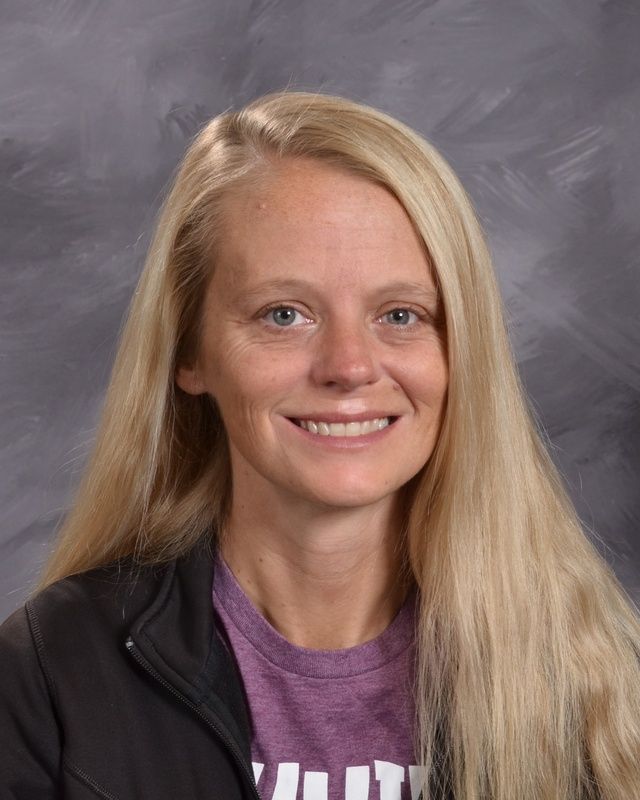 A woman with long blonde hair is smiling for the camera