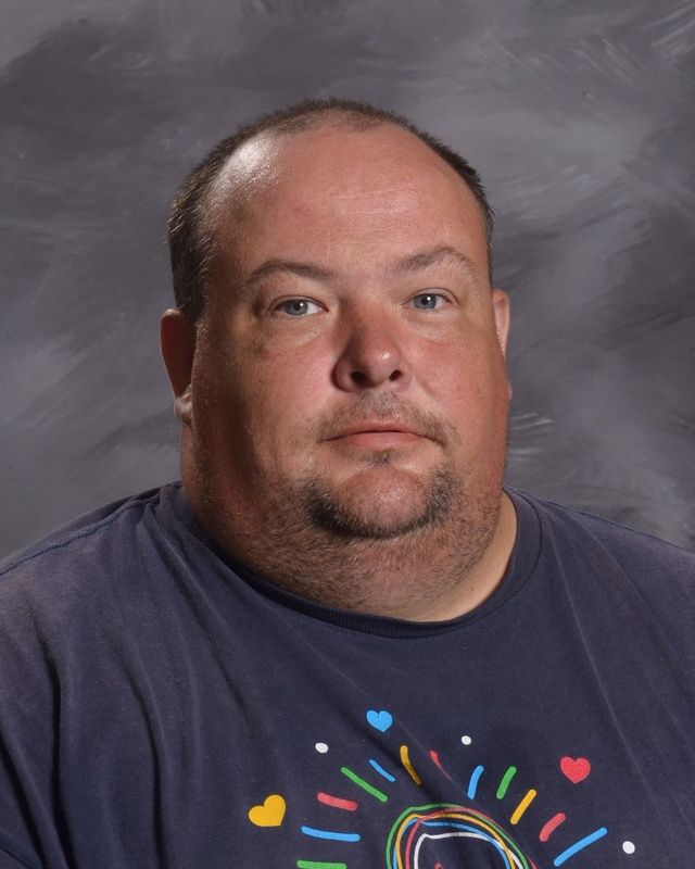 A man with a beard is wearing a blue t-shirt