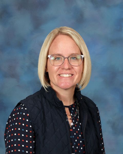 Women with short blonde hair and glasses smiling for the camera