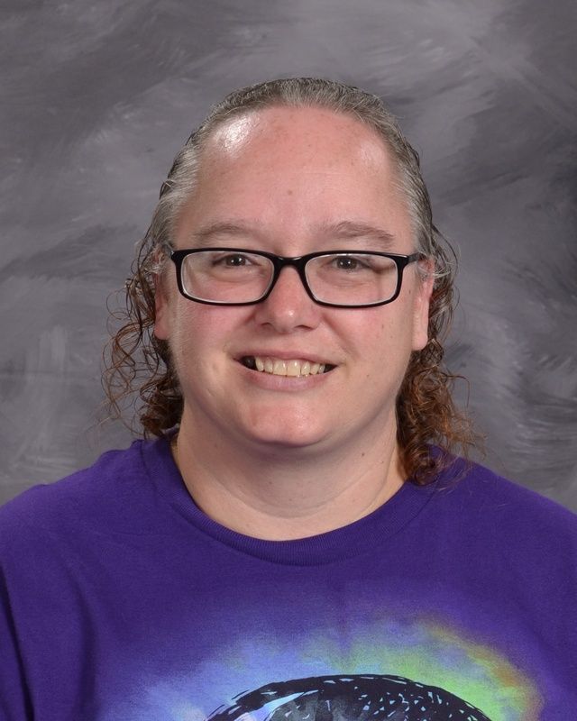A woman wearing glasses and a purple shirt