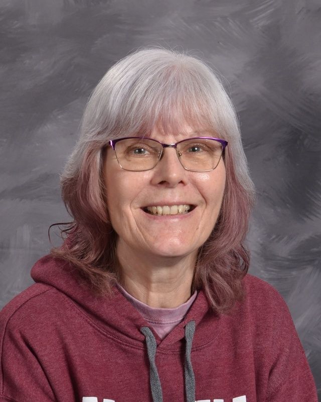 Woman wearing glasses and a maroon hoodie posing for the camera