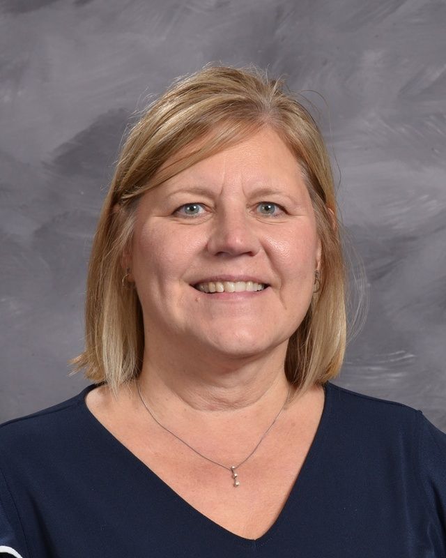 A women with blonde hair smiling for the camera