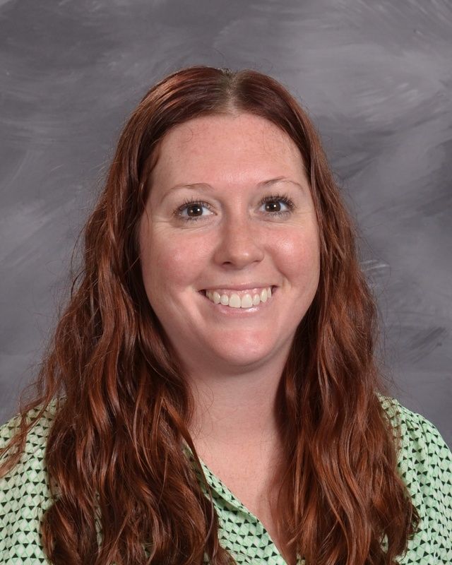 A woman with long hair is smiling for the camera.