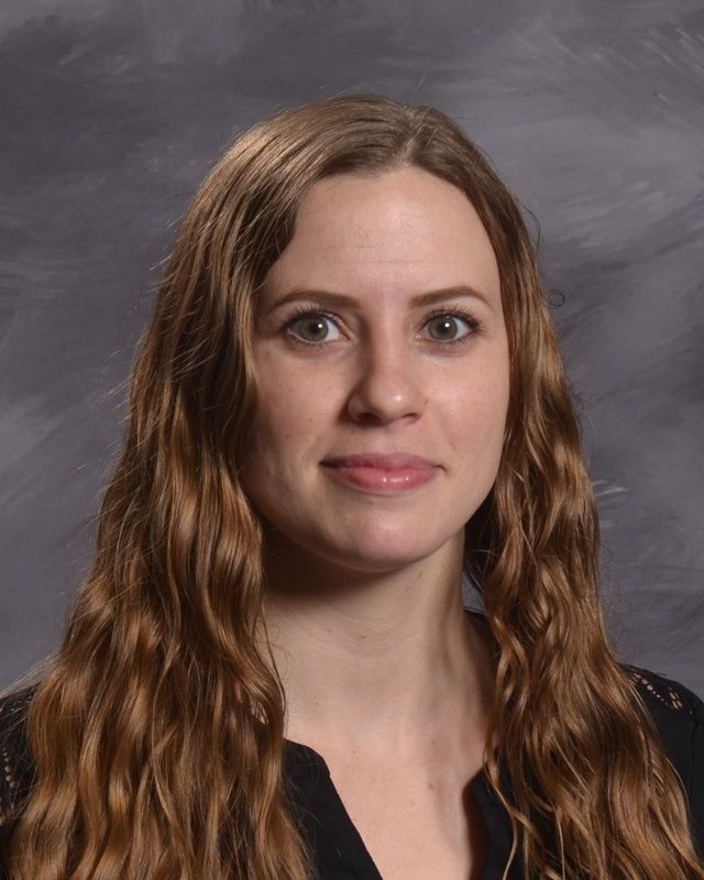 A woman in a black shirt is smiling for the camera.