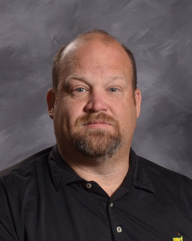A man with a beard is wearing a black shirt posing for the camera