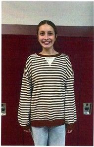 A girls wearing a striped shirt smiling for the camera