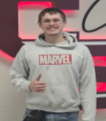 A boy wearing a grey Marvel hoodie smiling for the camera