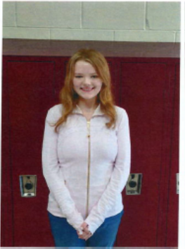 A girl with long hair smiling for the camera