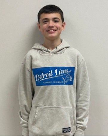 A girls wearing a striped shirt smiling for the camera