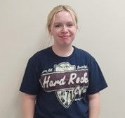A girl wearing a blue Hard Rock t-shirt smiling for the camera