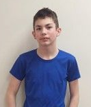 A boy wearing a blue t-shirt posing for the camera