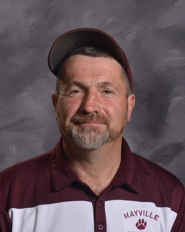 A man with a beard wearing a hat and a maroon shirt