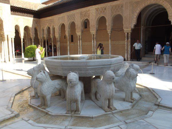 A fountain surrounded by statues of lions in a courtyard