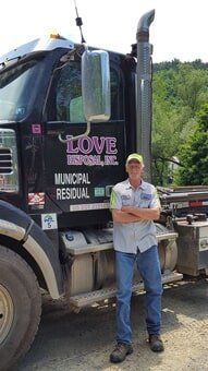 Worker Beside the Black Truck — Lock Haven, PA — Love Disposal, Inc.