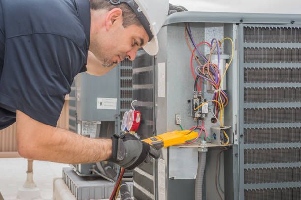 A man is working on an air conditioner with a pair of pliers.
