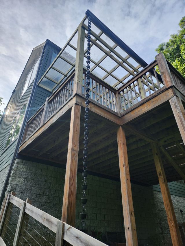 A wooden deck with a rain chain attached to it.