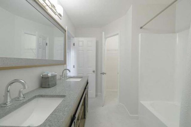 A bathroom with two sinks and a bathtub