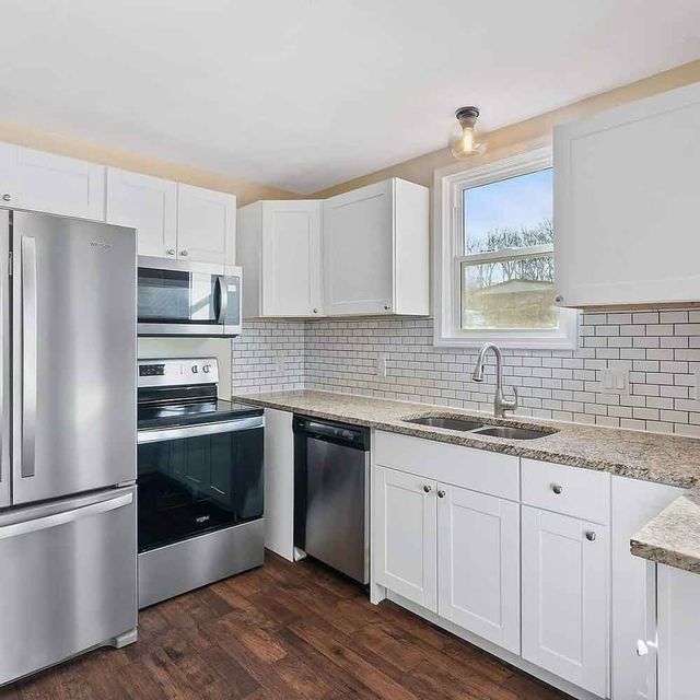 A kitchen with stainless steel appliances and white cabinets