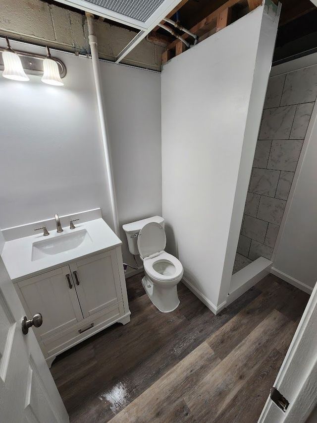 A bathroom with a toilet , sink and shower.