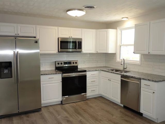 A kitchen with stainless steel appliances and white cabinets