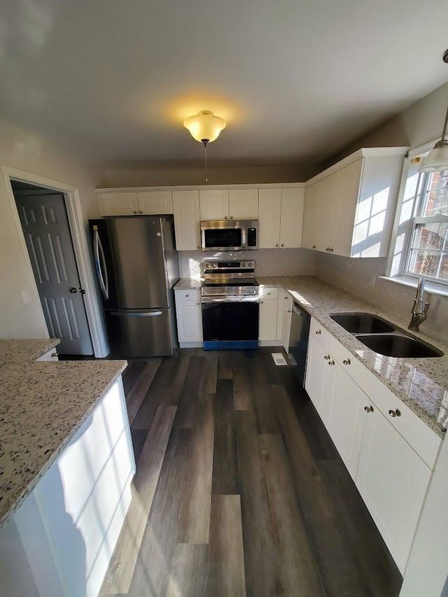 A kitchen with stainless steel appliances and granite counter tops.