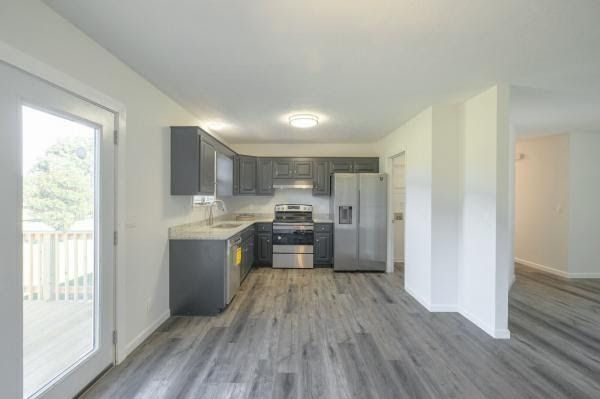 A kitchen with stainless steel appliances and gray cabinets