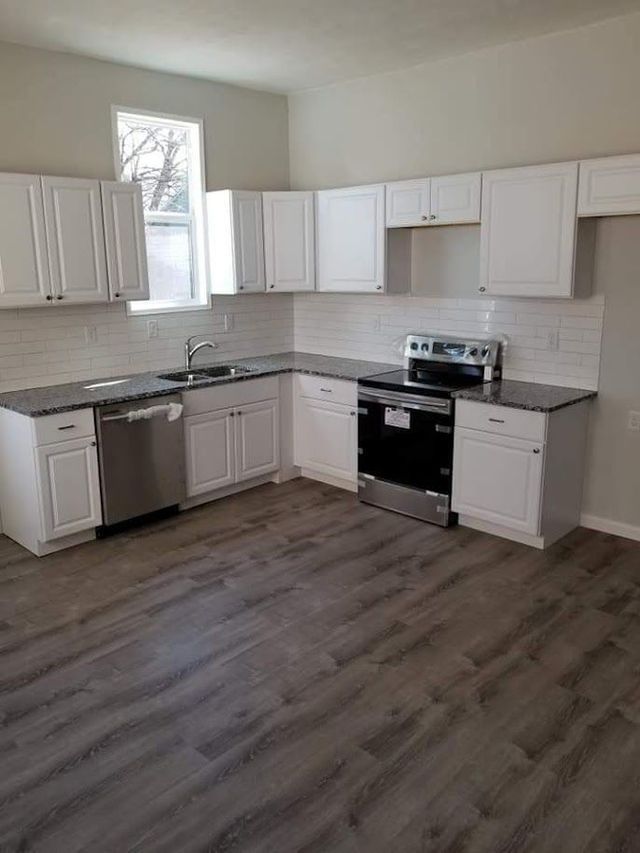 A kitchen with white cabinets and stainless steel appliances.