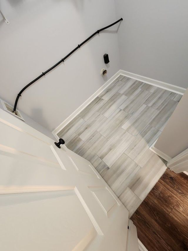 A laundry room with a wooden floor and stairs