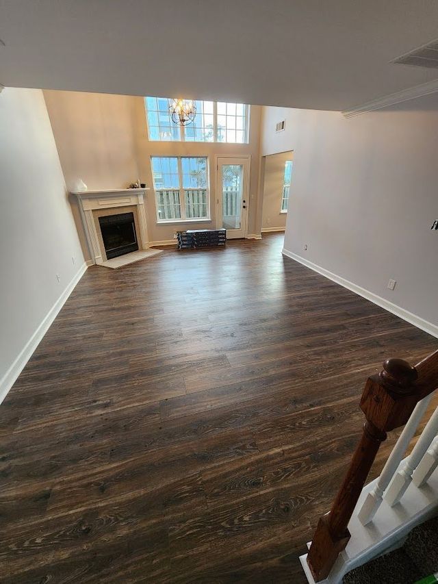 An empty living room with hardwood floors and a fireplace.