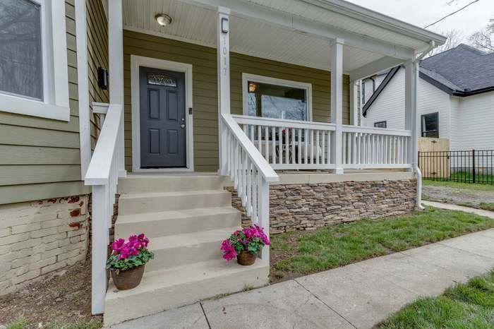 A house with a porch and stairs leading up to it.