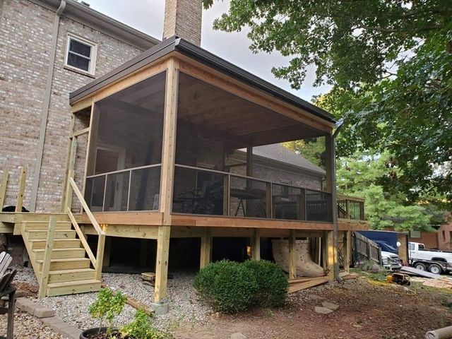 A screened in porch is being built on the side of a house.