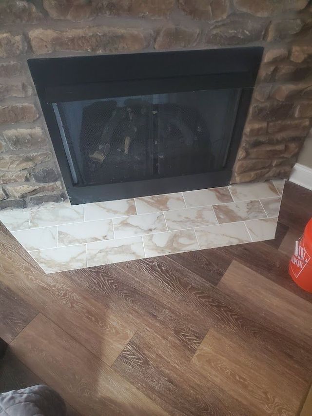 A fireplace in a living room with a wooden floor.