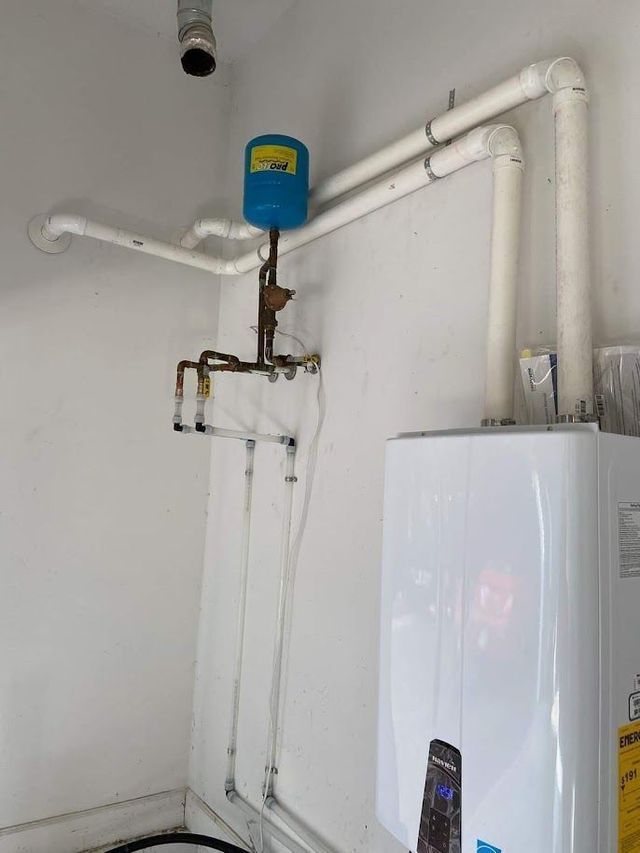 A water heater is sitting in a room next to a wall.