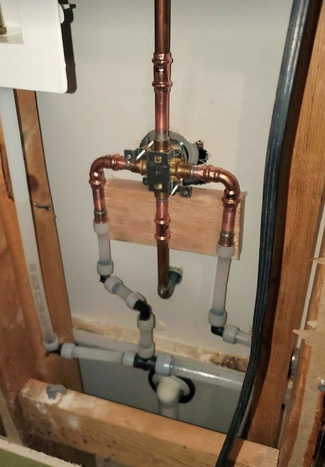 Copper pipes are connected to a bathtub in a bathroom