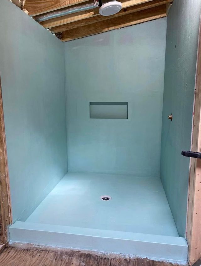 A bathroom with a shower and a ceiling fan.