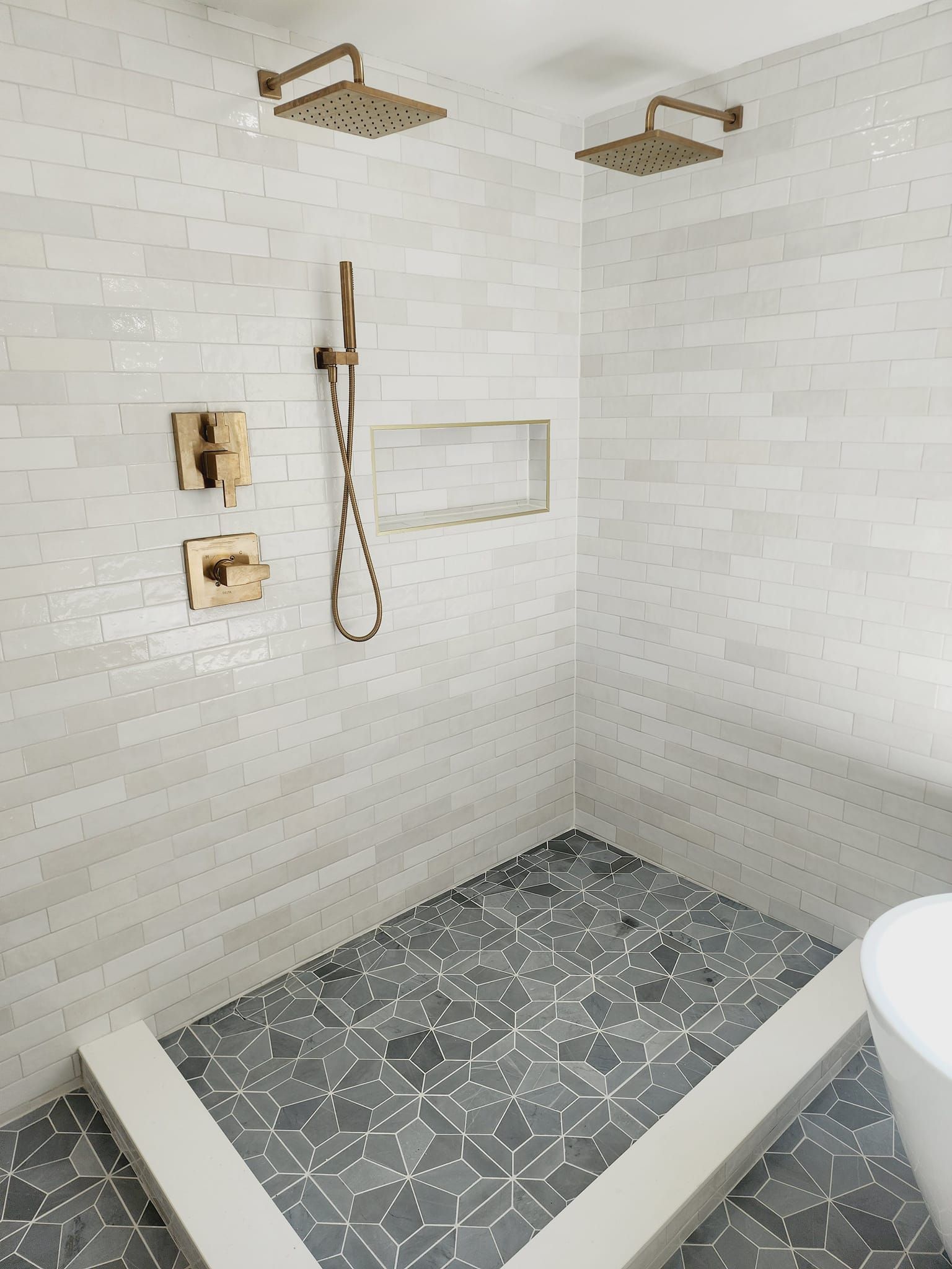 A bathroom with two shower heads and a bathtub