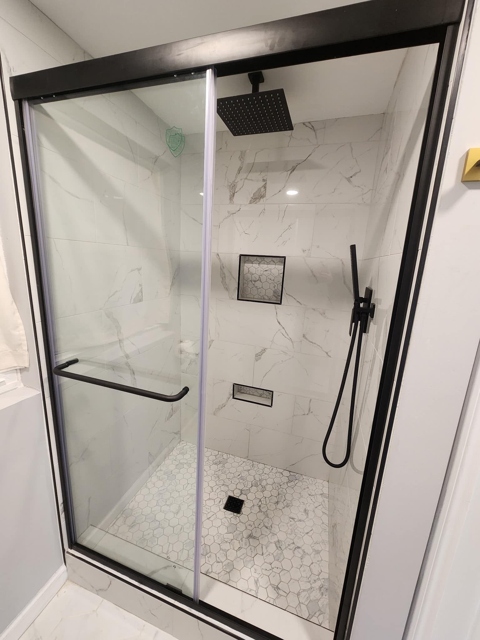 A shower stall with a black frame and a shower head