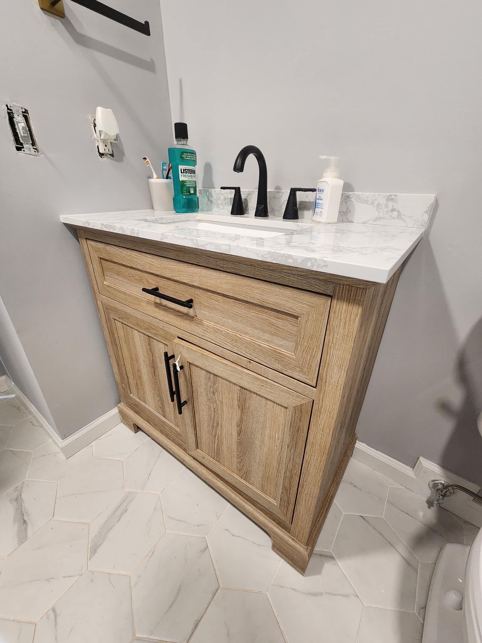 A bathroom vanity with a sink and a toilet