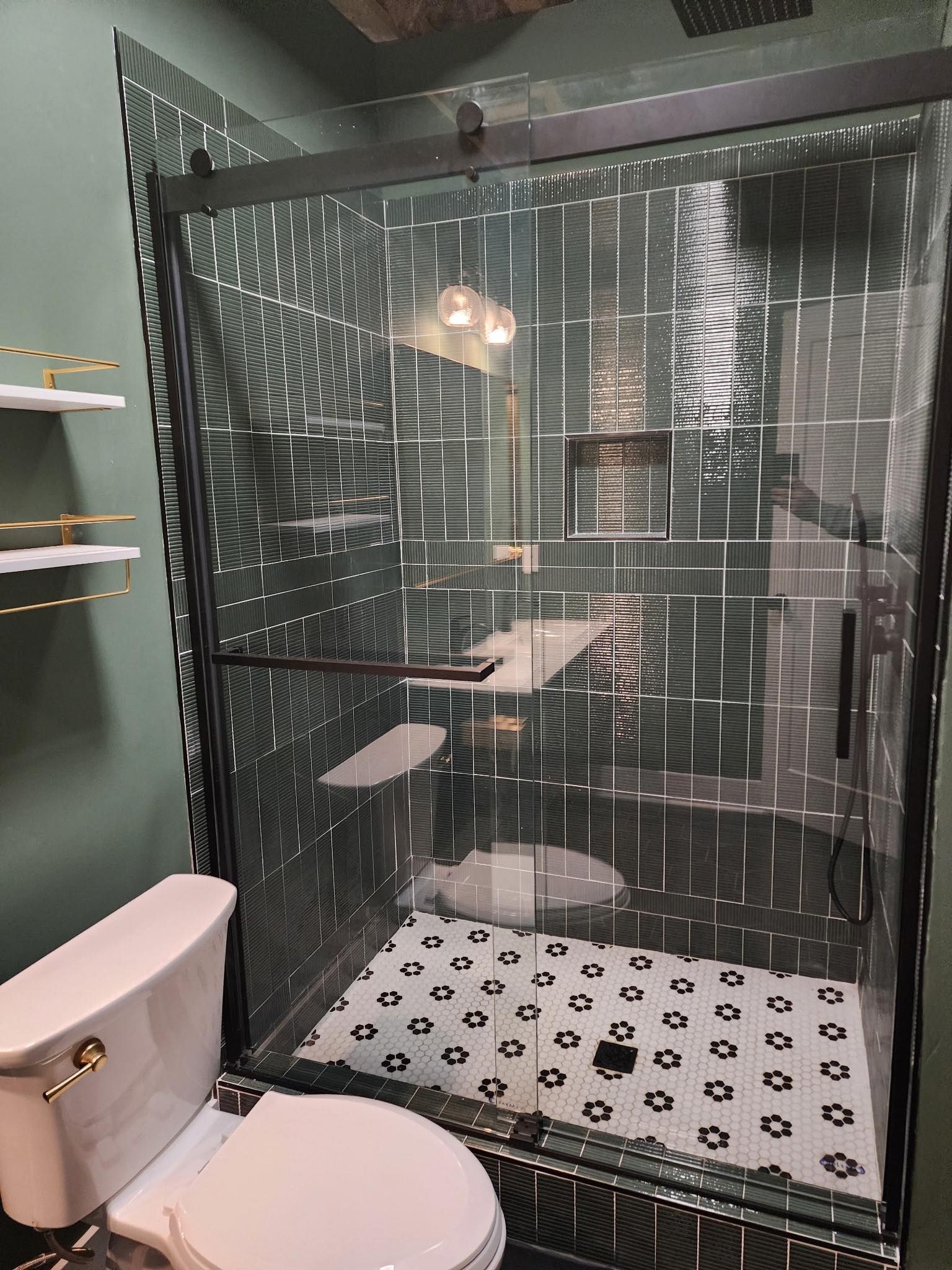 A bathroom with a toilet, sink , and shower stall