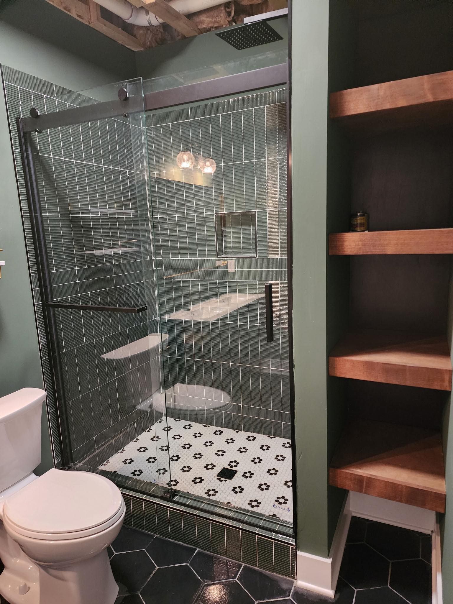 A bathroom with a toilet, shower and shelves