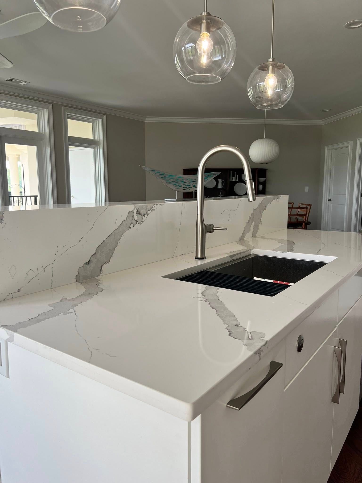 A kitchen with white cabinets, a sink, and a faucet