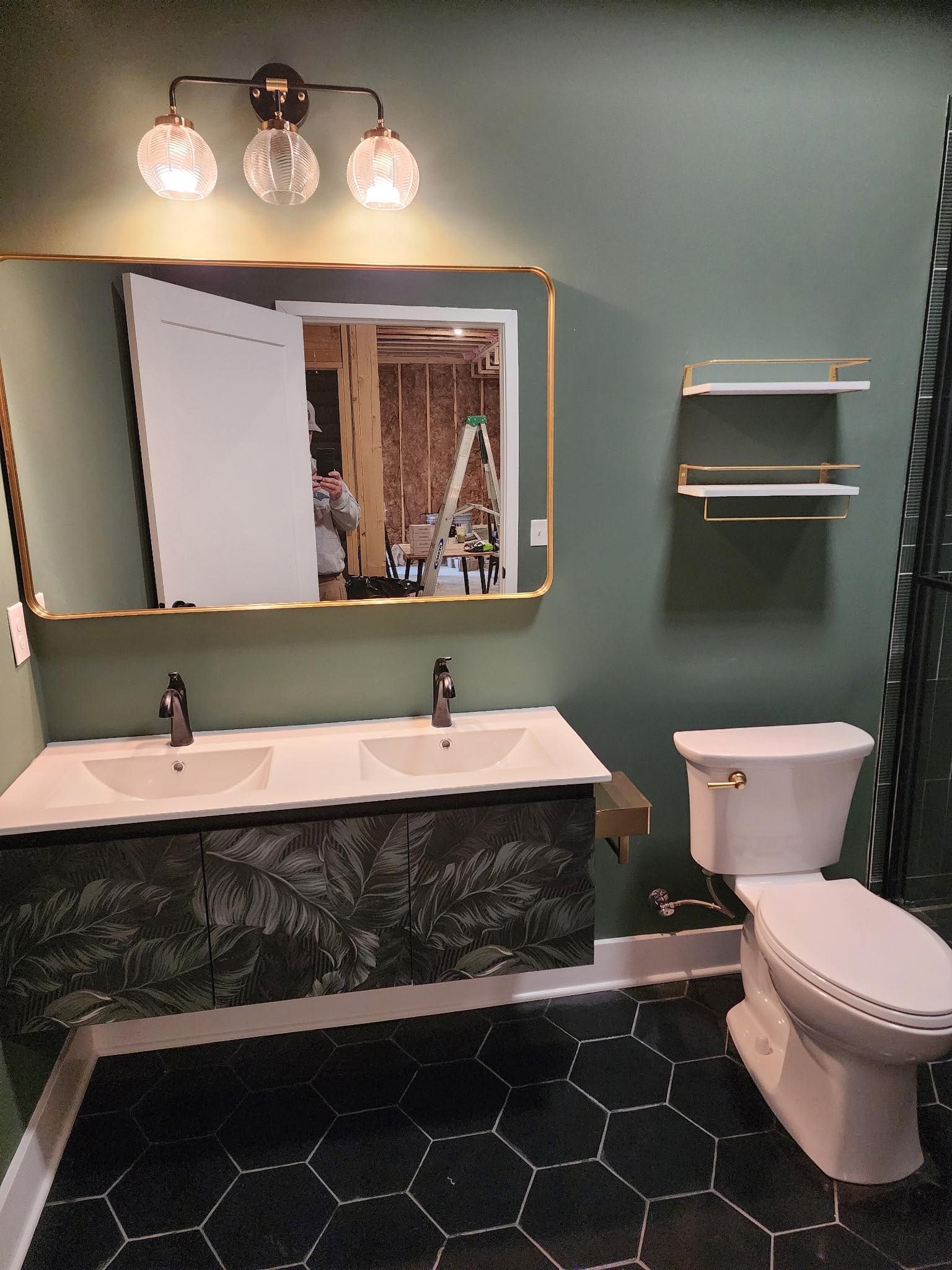 A bathroom with two sinks, a toilet, and a large mirror