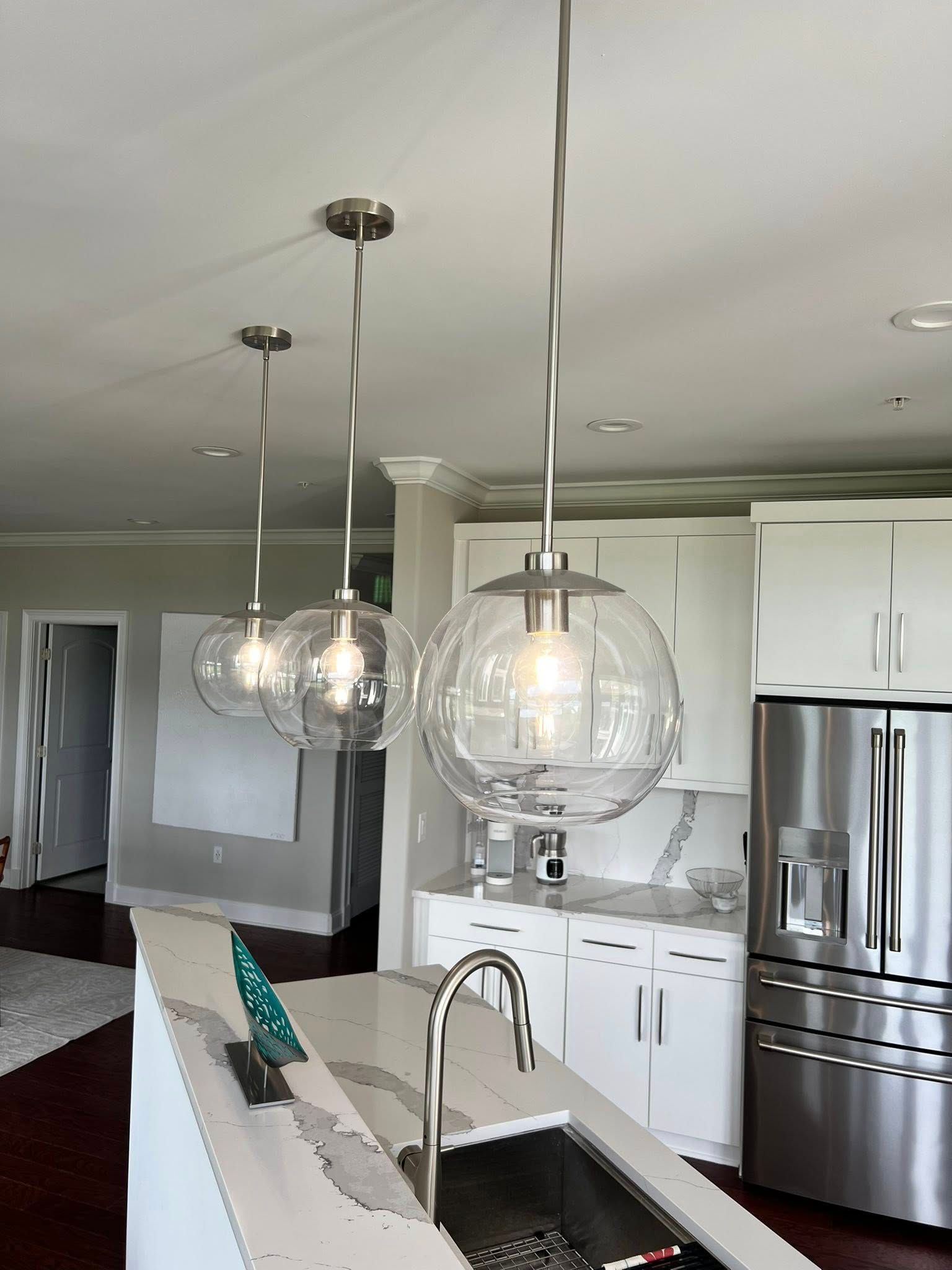 A kitchen with a sink, refrigerator, and stainless steel appliances