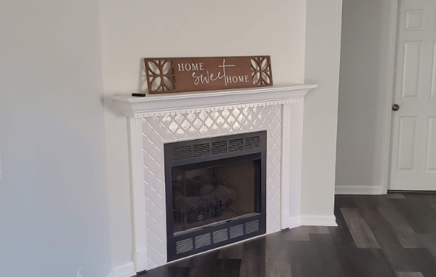 A fireplace with a sign on top of it in a living room.