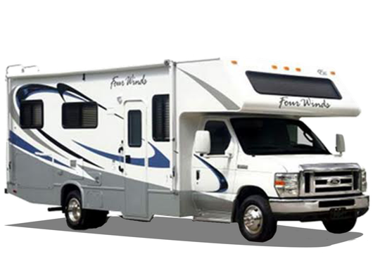 White Four Winds RV with blue and gray accents parked outdoors.